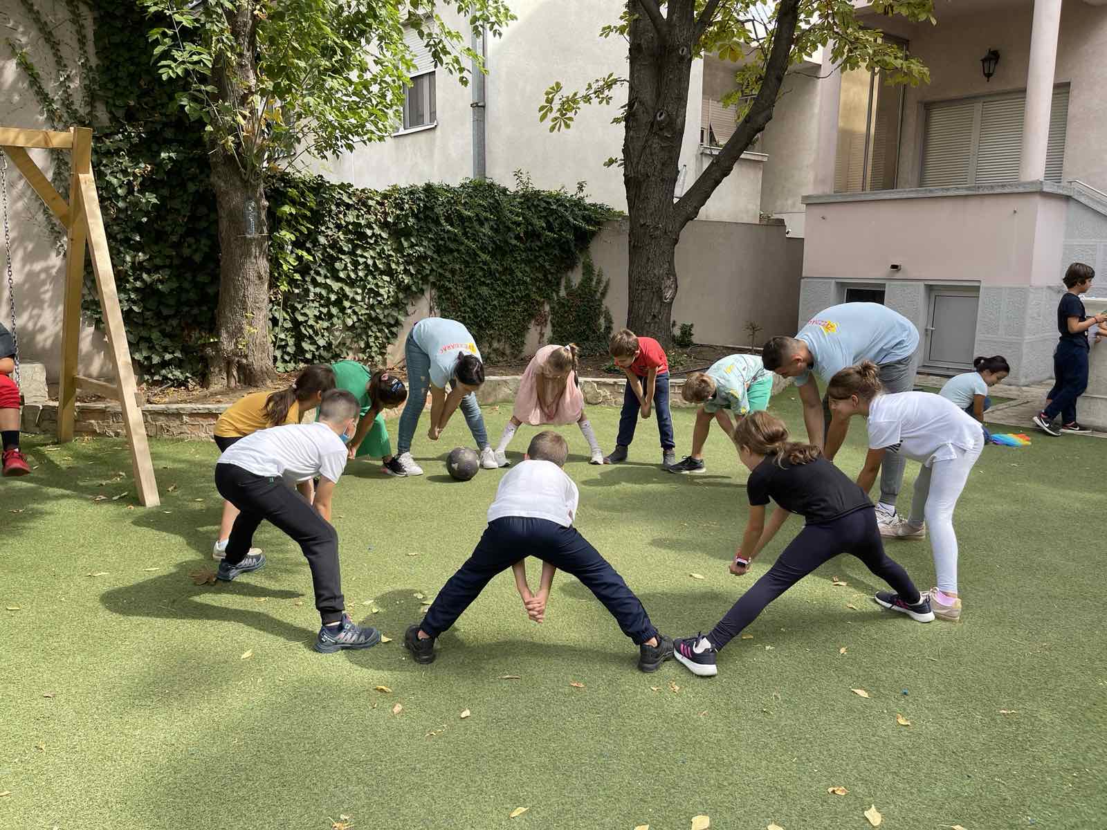 Osnovci na dvorištu rade vežbe zagrevanja