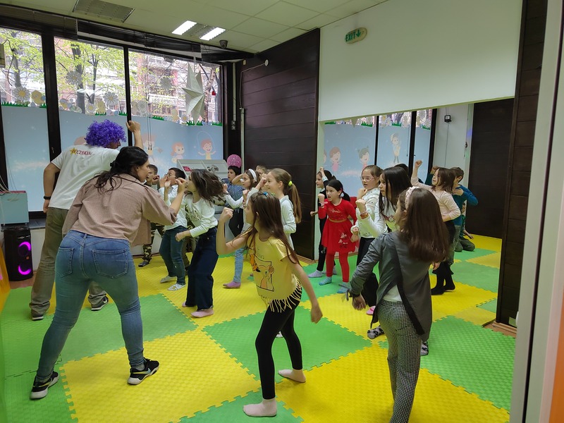 Devojčica se smeje sa rukama ispruženim visoko uvis