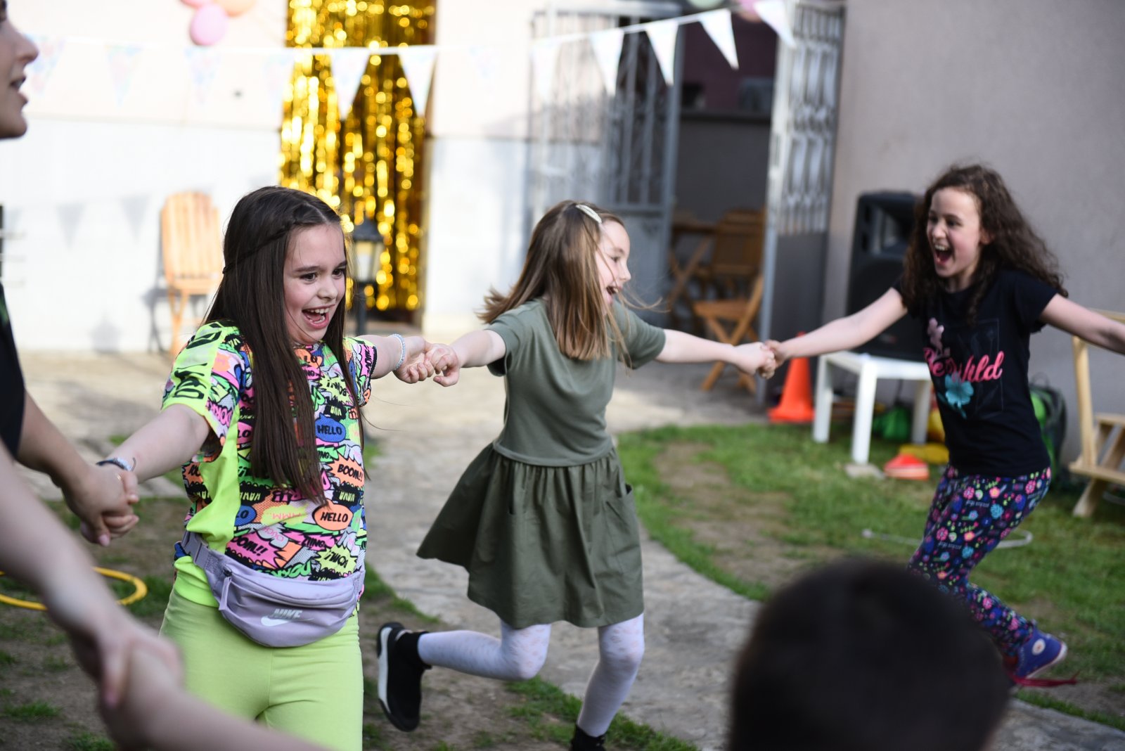 deca se drže za ruke pevajući i igrajući